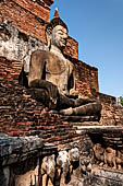 Thailand, Old Sukhothai - Wat Mahathat, square-based, multi-layered chedi with statues of seated Buddha at each side, stucco figures of lions and elephants decorate the base. 